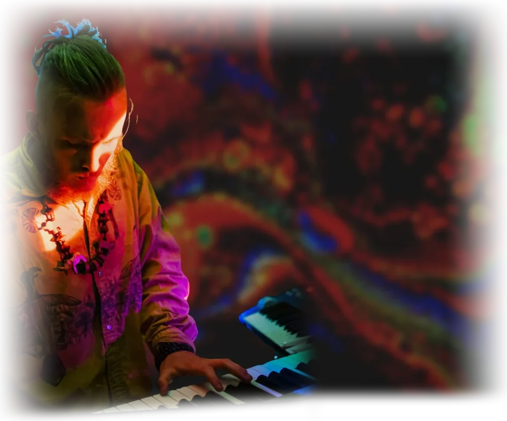 Gray Contrast playing keys, a patch of light on his face, in front of a colourful projection