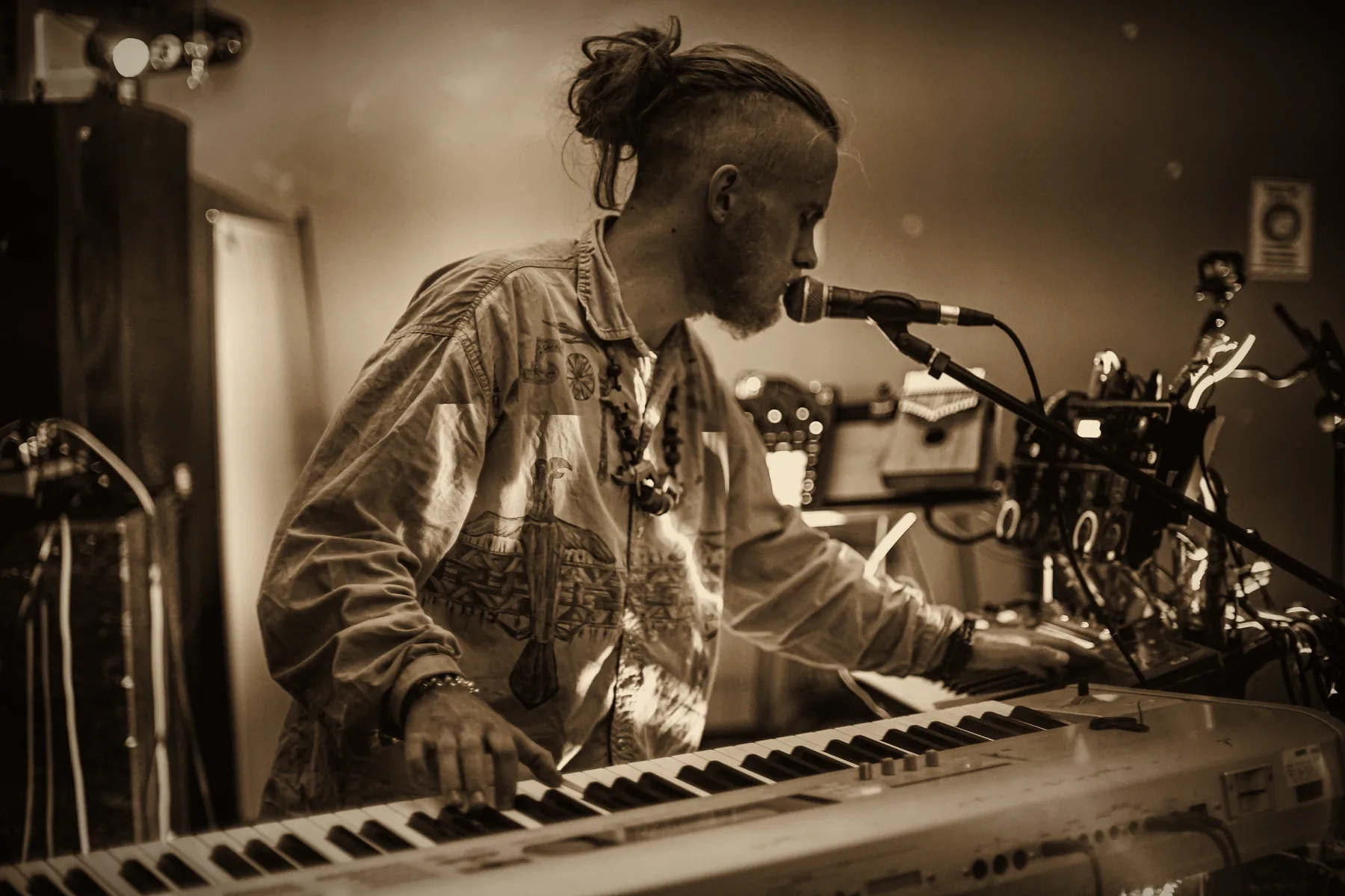 Gray Contrast singing into a microphone while playing keys, sepia photo