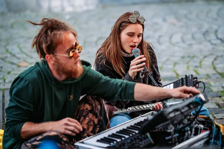 Gray Contrast at his keys with vocalist KIM singing on a cobblestone street